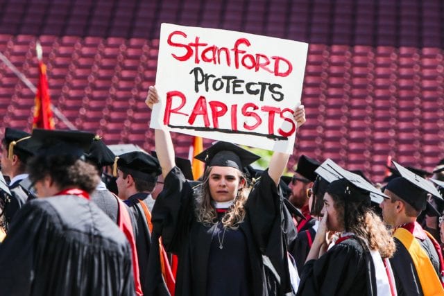 A woman carries a sign in solidarity for a Stanford rape victim during graduation at Stanford University, in Palo Alto, California, on June 12, 2016. Stanford students are protesting the universitys handling of rape cases alledging that the campus keeps secret the names of students found to be responsible for sexual assault and misconduct. / AFP / GABRIELLE LURIE (Photo credit should read GABRIELLE LURIE/AFP/Getty Images)