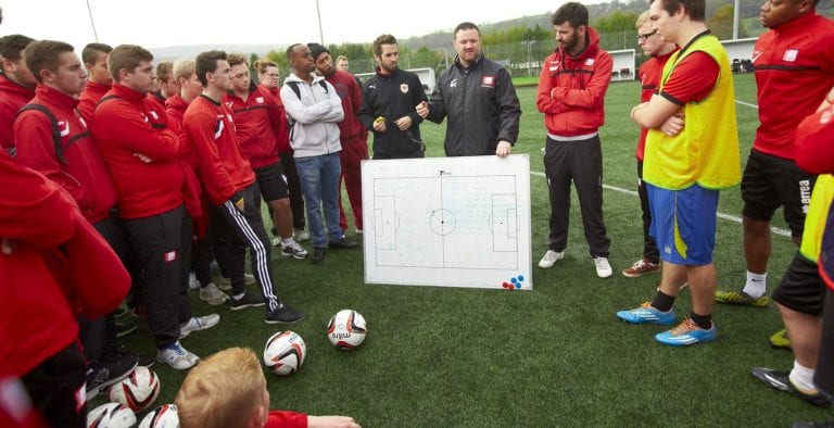 тренер объясняет тактику команде игроков