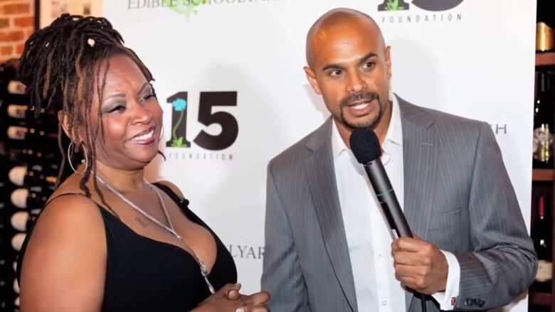 Robin Quivers smiles beside a host at a public event
