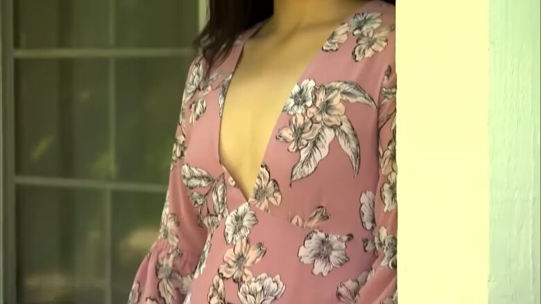 Woman in a pink floral dress standing near a doorway
