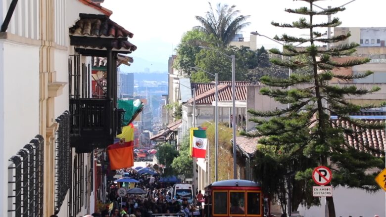 Colorful flags and a busy street in a historic South American city