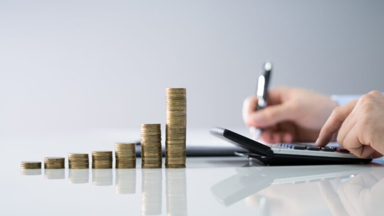 Coin stacks beside a calculator for child support costs