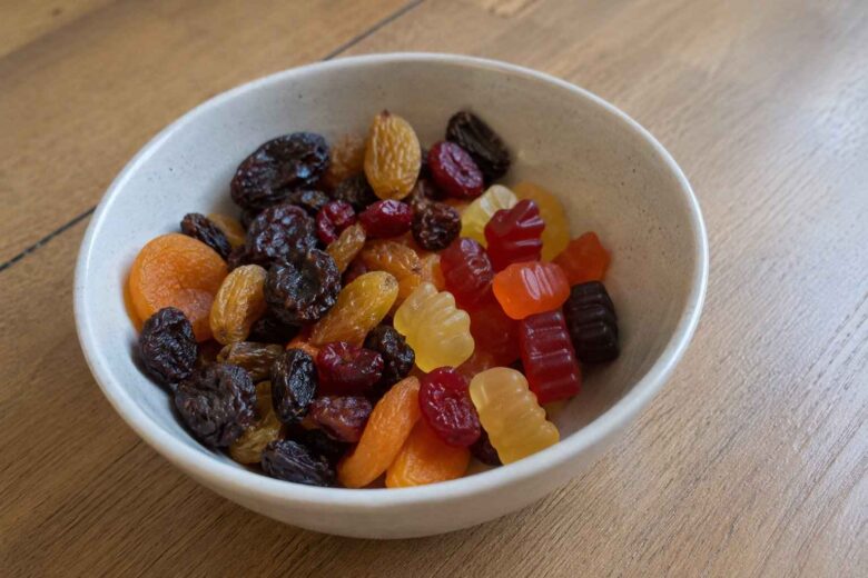 Bowl filled with dried fruit and colorful gummy vitamins.