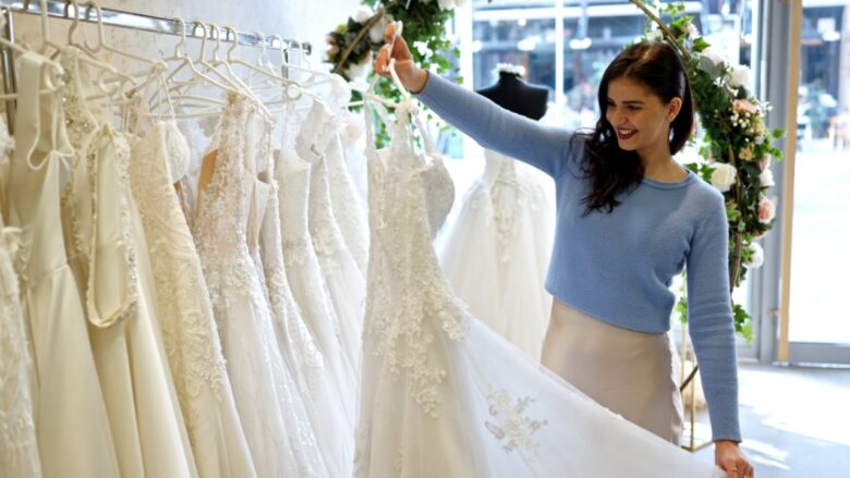Woman browses white bridal gowns at a boutique