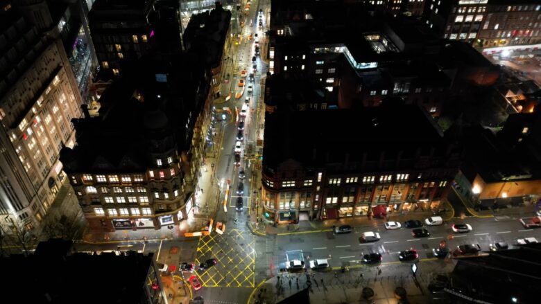 Aerial view of Manchester city centre streets at night.