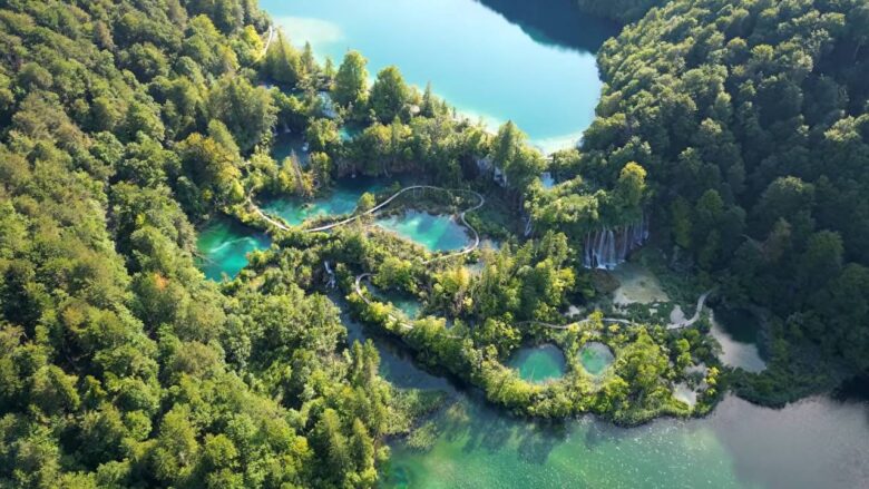 Aerial view of turquoise lakes, waterfalls and wooden walkways at Plitvice Lakes.