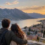 Couple overlooks the Bay of Kotor and its coastal villages at sunset in autumn.