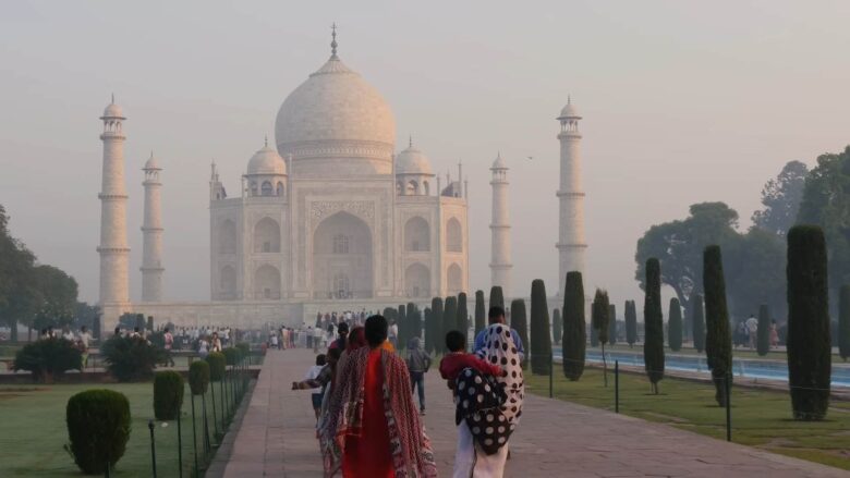 Tourists approaching the Taj Mahal through its landscaped gardens in Agra.