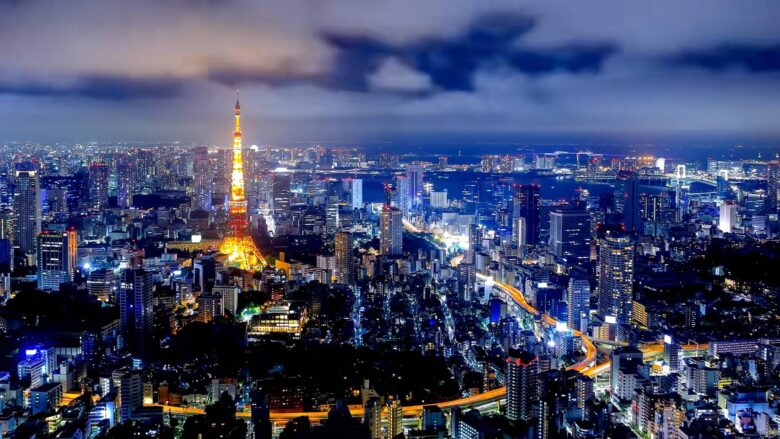 Night view of Tokyo with Tokyo Tower, skyscrapers and illuminated roads.