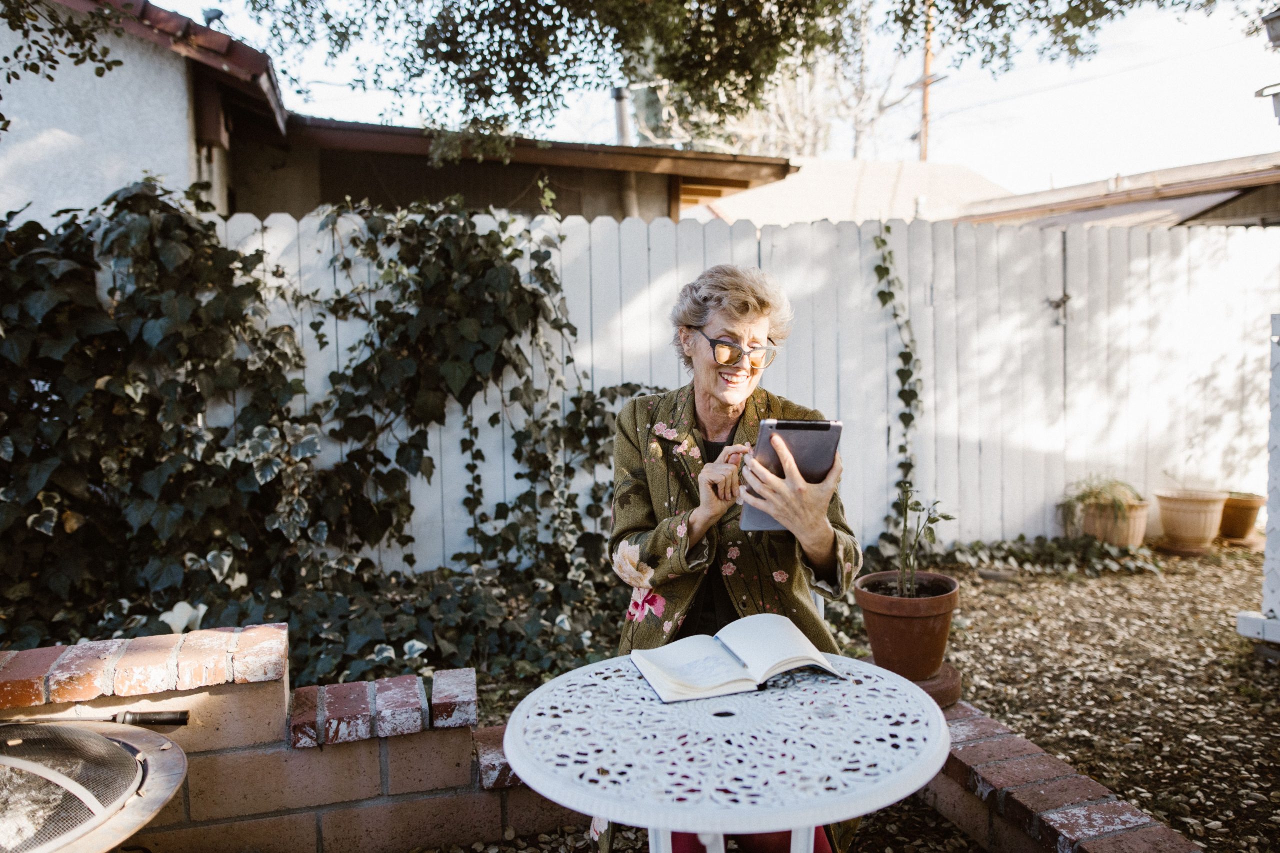 Homeowner using a tablet while relaxing in an outdoor garden